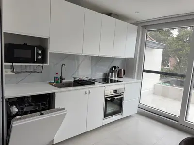 a white kitchen with a sink and a microwave at Beautiful house &parking space in Leuven