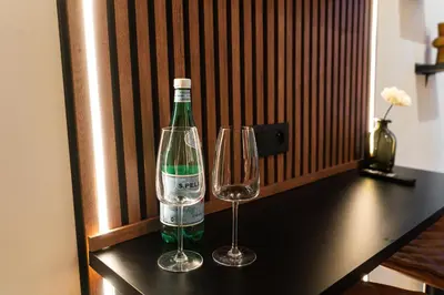 a bottle of wine and two glasses on a table at Spacious & Stylish 3 adjacent Bedrooms Stay in Central Ghent in Ghent