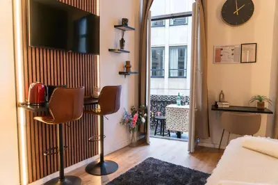 a living room with a flat screen tv on a wall at Spacious & Stylish 3 adjacent Bedrooms Stay in Central Ghent in Ghent