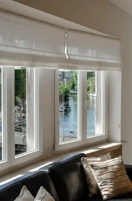 a living room with a couch and three windows at La Veduta - Luxe Apartment with Leie View in Ghent