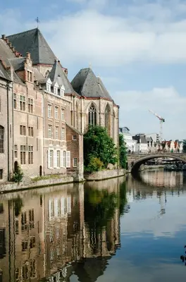 a bridge over a river in front of a building at La Veduta - Luxe Apartment with Leie View in Ghent
