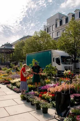 two people standing in a garden of flowers at La Veduta - Luxe Apartment with Leie View in Ghent