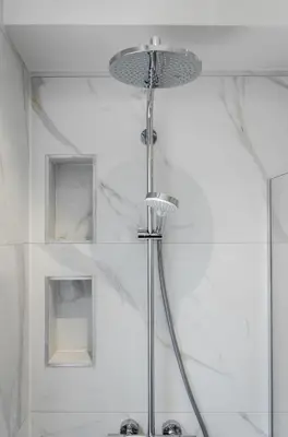 a shower head in a bathroom with white walls at La Veduta - Luxe Apartment with Leie View in Ghent