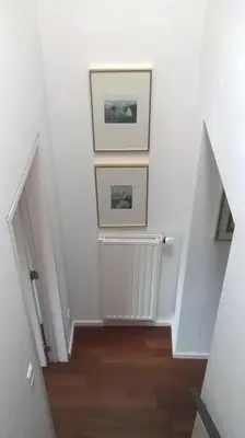 a hallway with two pictures on the wall and a radiator at Bvba Bacana in Rotselaar