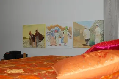 a bedroom with paintings on the wall and a bed at Bvba Bacana in Rotselaar