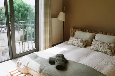 a teddy bear laying on a bed with a window at La Petite Foret Contemporary Apartment in Halle in Halle