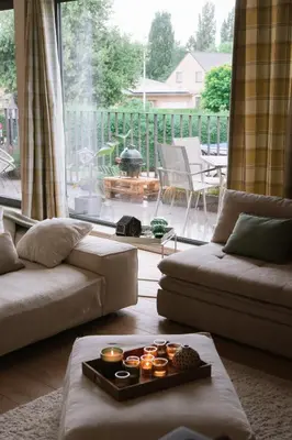 a living room with a couch and a large window at La Petite Foret Contemporary Apartment in Halle in Halle