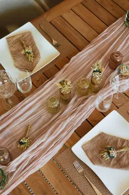 a wooden table with plates and glasses and flowers on it at La Petite Foret Contemporary Apartment in Halle in Halle