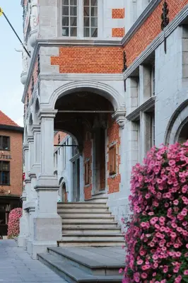 an entrance to a building with stairs and flowers at La Petite Foret Contemporary Apartment in Halle in Halle
