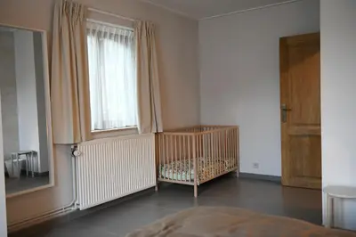 a crib in a room with a window at Vakantiewoning Nijkenhof in Ninove