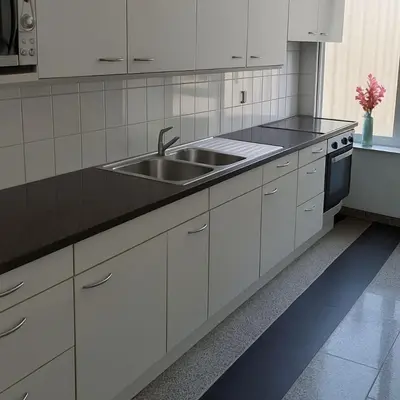 a kitchen with white cabinets and a sink at Belgielei business apartment in Antwerp