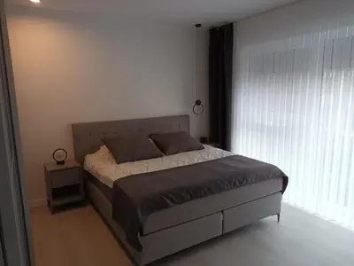 a bedroom with a bed and a large window at TML House in Boom