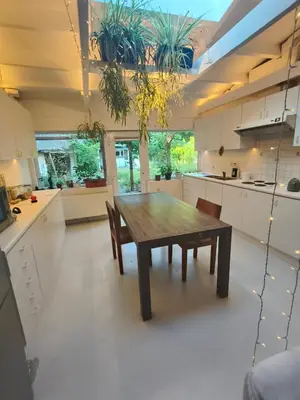 a kitchen with a wooden table and chairs at De roze kamer in Mol