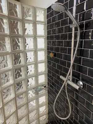 a shower in a bathroom with a brick wall at Urban Loft in Brussels West in Brussels
