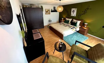 a bedroom with a bed and a table and chairs at Villa Grenszicht in Nispen
