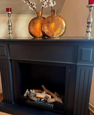 a black fireplace with three vases on top of it at Villa Grenszicht in Nispen