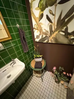 a green tiled bathroom with a sink and a tub at Villa Grenszicht in Nispen