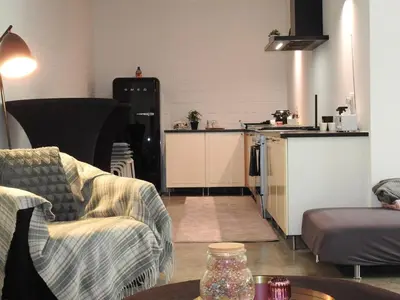 a living room with two couches and a kitchen at Casa Milo in Lokeren