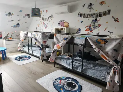 a bedroom with three bunk beds and a wall with planets at Tomorrowland rooms in Rumst