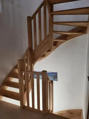 a wooden staircase in a room with a white wall at Tomorrowland rooms in Rumst