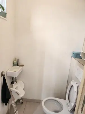 a white bathroom with a toilet and a sink at Tomorrowland rooms in Rumst