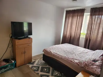 a bedroom with a bed and a television on a dresser at Tomorrowland rooms in Rumst