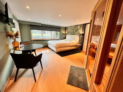 a bedroom with a bed and a table and a chair at Studio with sauna in Meise