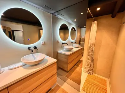 a bathroom with two sinks and two mirrors at Studio with sauna in Meise