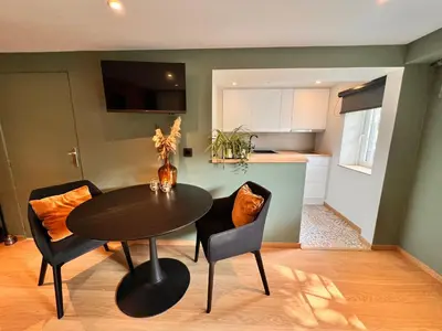 a dining room with a table and chairs and a kitchen at Studio with sauna in Meise
