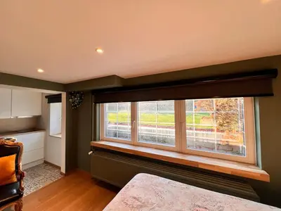 a bedroom with a large window in a room at Studio with sauna in Meise
