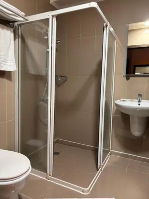 a bathroom with a shower and a toilet and a sink at Escale Hotel in Brussels