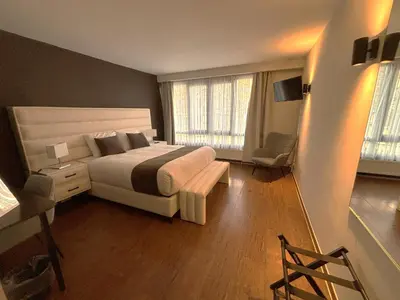 a bedroom with a large bed and two windows at Escale Hotel in Brussels