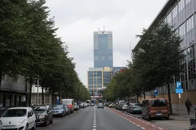 a city street with parked cars and a tall building at Escale Hotel in Brussels