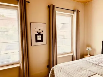 a bedroom with a bed next to a window at Charmante woning in de Vlaamse Ardennen in Sint-Lievens-Houtem