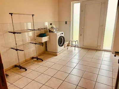 a laundry room with a washing machine and a tiled floor at Charmante woning in de Vlaamse Ardennen in Sint-Lievens-Houtem