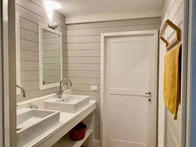a white bathroom with two sinks and a mirror at A Calm & Quiet Stay in Wuustwezel