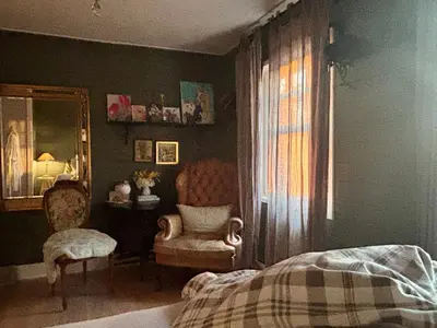 a bedroom with a bed and a chair and a window at A Calm & Quiet Stay in Wuustwezel