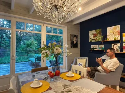 a man sitting at a table in a dining room at A Calm & Quiet Stay in Wuustwezel