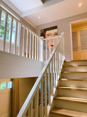 a staircase in a home with a painting on the wall at A Calm & Quiet Stay in Wuustwezel