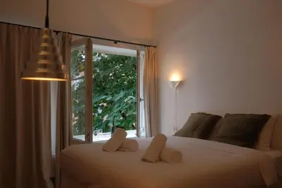a bedroom with a bed with a large window at Studio Nolo by Simone Antwerp in Antwerp