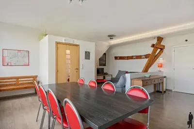 a dining room with a wooden table and red chairs at Klavertje Lier Pallieter in Lier