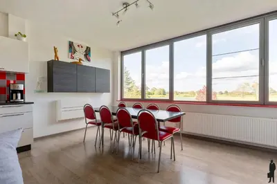 a dining room with a table and red chairs at Klavertje Lier Pallieter in Lier