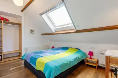 a bedroom with a colorful bed and a skylight at Klavertje Lier Pallieter in Lier