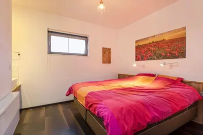 a bedroom with a bed with a painting on the wall at Klavertje Lier Schapenstal in Lier