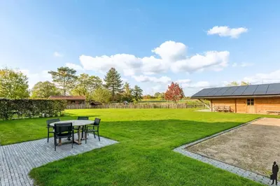 a patio with a table and chairs in a yard at Klavertje Lier Schapenstal in Lier