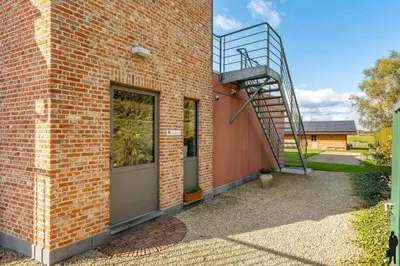 a brick building with a staircase on the side of it at Klavertje Lier Schapenstal in Lier