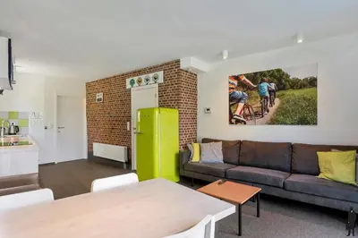 a living room with a couch and a green refrigerator at Klavertje Lier Schapenstal in Lier