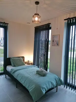 a bedroom with a bed in a room with windows at Sandrise in Balen