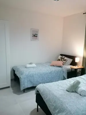 a bedroom with two beds and a table with a lamp at Sandrise in Balen