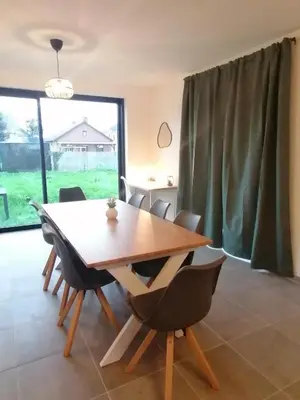 a dining room with a wooden table and chairs at Sandrise in Balen